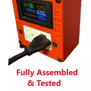 May include: A red power meter with a digital display showing voltage, current, wattage, and frequency. The meter has a standard electrical outlet and a black power cord plugged in. The text "POWER METER" is printed on the side of the meter. The text "Fully Assembled & Tested" is printed below the meter.