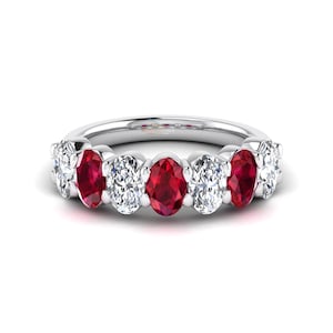 May include: A silver ring featuring a series of oval-cut gemstones. Alternating between vibrant red rubies and clear, sparkling diamonds, the ring presents a classic and elegant design. The gemstones are set closely together, creating a continuous band of color and brilliance.