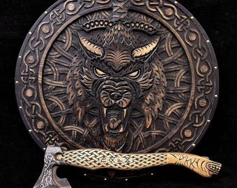 May include: A wooden shield with a carved wolf head and intricate Celtic knotwork design. The shield is decorated with gold accents and has a small axe with a braided handle.