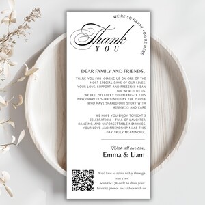 May include: A white thank you card with black script and a decorative font. The card includes a message to family and friends, a QR code, and the names Emma & Liam. The card is on a white plate.