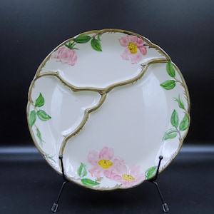 May include: A white ceramic mug with a black handle and the text "But First, Coffee" in a handwritten style. The mug is on a white surface. The mug is approximately 4 inches tall.