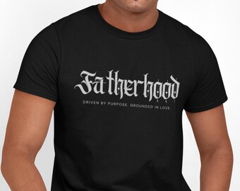 May include: Black t-shirt with a white graphic that says "Fatherhood" in a gothic font. The text below the graphic says "Driven by purpose. Grounded in love."