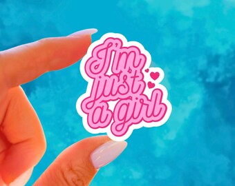 May include: A pink sticker with the phrase "I'm just a girl" in a cursive font, outlined in white. The sticker has a white border and small pink hearts. The background is a gradient of blue.