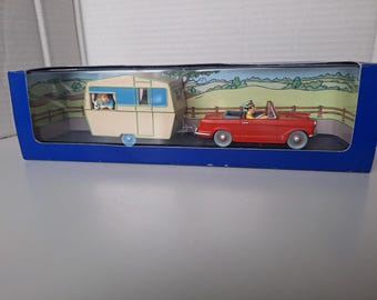 A car with a caravan from the album: Tintin and the Black Island
