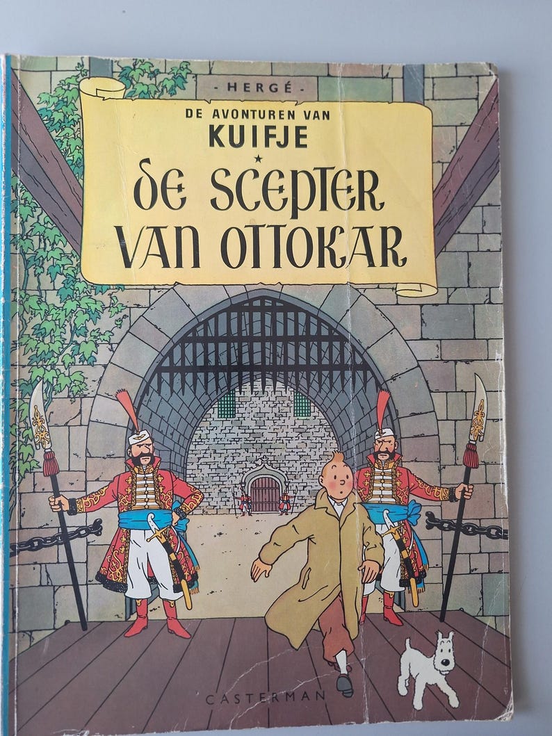 May include: A vintage comic book cover featuring a cartoon illustration. The title "De Scepter Van Ottokar" is displayed on a yellow scroll. The cover depicts a man in a tan coat running, with two guards and a dog.