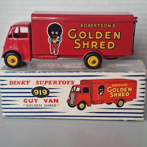 May include: A red Dinky Supertoys 919 Guy Van toy lorry with yellow wheels. The side of the van features a graphic of a character and the text Robertson's Golden Shred. The lorry sits on its original white and blue striped cardboard box.