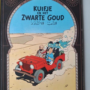 May include: A vintage comic book cover featuring a red jeep driving through a desert landscape. The title "Kuifje en het Zwarte Goud" is displayed in large letters, with additional text in Arabic. The cover has a decorative border.