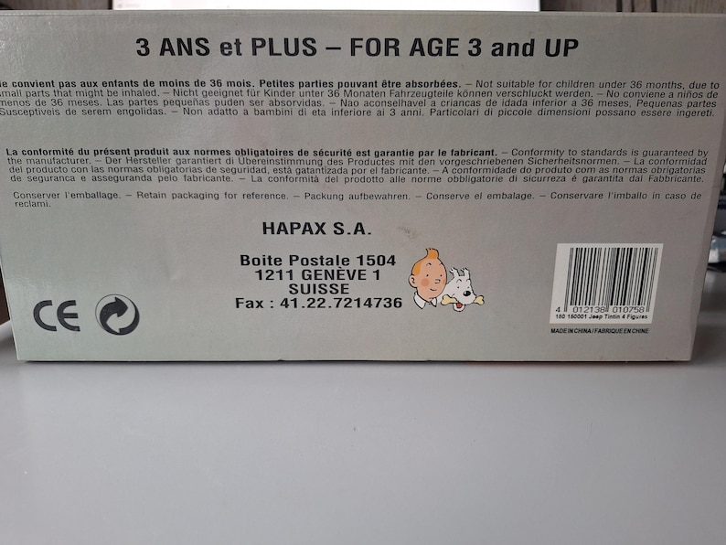 May include: A white ceramic mug with a black handle and the text "But First, Coffee" in a handwritten style. The mug is on a white surface. The mug is approximately 4 inches tall.