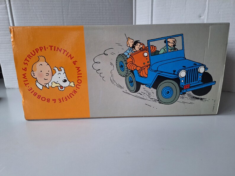 May include: A white ceramic mug with a black handle and the text "But First, Coffee" in a bold, black font. The mug is set against a blurred background, suggesting a cozy setting. The mug appears to be approximately 4 inches tall.