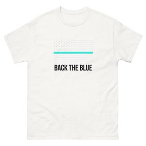 May include: White t-shirt featuring a blue and white American flag with a thin blue line across the middle. The text "BACK THE BLUE" is printed below the flag.