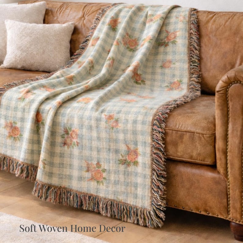 Grandma core woven blanket with fringe draped across a warm leather sofa