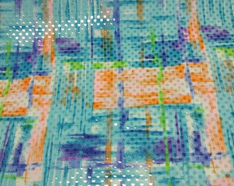 May include: Abstract patterned fabric with a blue, green, orange, and purple design. The fabric has a white polka dot pattern.