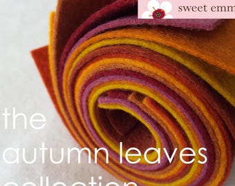 May include: A roll of felt fabric in various shades of orange, red, and yellow. The felt is rolled up and the ends are visible. The text "the autumn leaves collection" is written below the roll of felt. The text "sweet emma jean" is written in a white box with a pink flower in the upper right corner of the image.