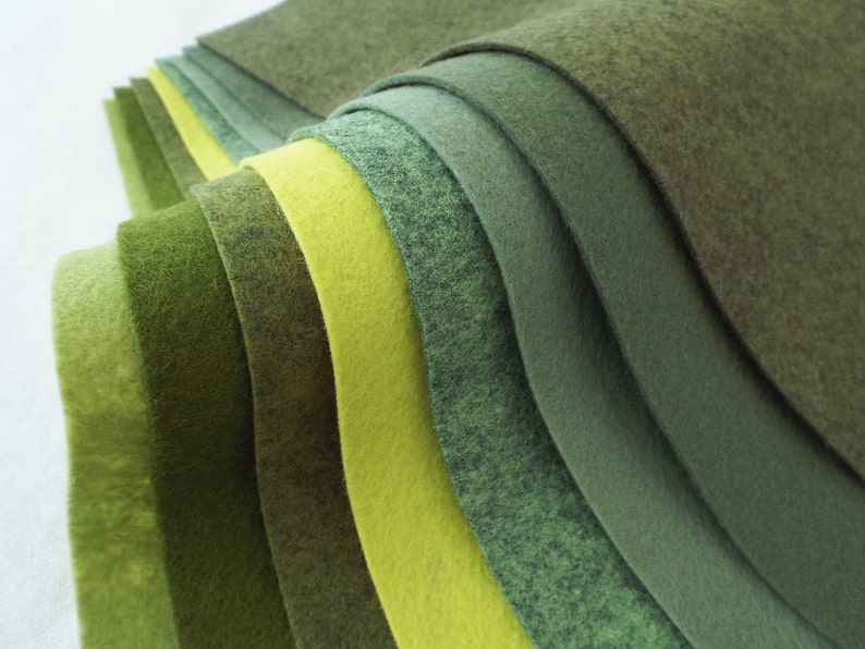 Puede incluir: Una colecci&oacute;n de hojas de fieltro en varios tonos de verde y amarillo. Las hojas est&aacute;n dispuestas en semic&iacute;rculo, con el verde m&aacute;s oscuro en la parte superior y el amarillo m&aacute;s claro en la parte inferior.