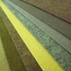 Puede incluir: Una colecci&oacute;n de muestras de tela de fieltro en varios tonos de verde y amarillo. Las muestras est&aacute;n dispuestas en forma de abanico, con el verde m&aacute;s oscuro en la parte superior y el amarillo m&aacute;s claro en la parte inferior.