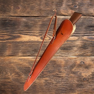 Puede incluir: Una funda de arma de cuero marrón con una correa para el hombro. La funda tiene una solapa que se cierra con un broche a presión. La funda está hecha de cuero de alta calidad y está diseñada para proteger tu arma.