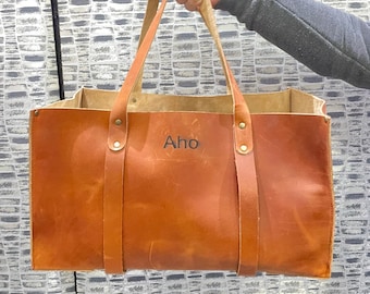 Könnte beinhalten: Eine große braune Ledertasche mit einer einzigen personalisierten Aufschrift: "Aho".