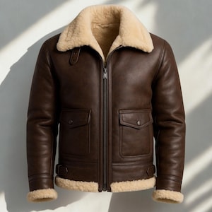 May include: A brown leather jacket with a cream shearling collar and lining. The jacket has a zip-up front, two front pockets, and adjustable straps at the waist and cuffs. A classic style, ideal for colder weather, with a warm, inviting look.