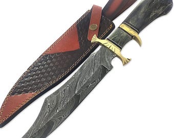 May include: A Damascus steel hunting knife with a brown leather sheath. The knife has a black handle with gold accents and a decorative design.