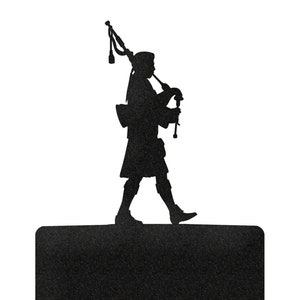 May include: Black light switch cover with a silhouette of a bagpipe player on top. The cover is made of metal and has a textured finish.
