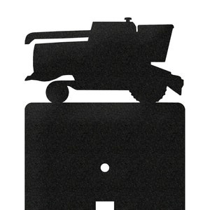 May include: Black metal light switch cover with a silhouette of a combine harvester on top.