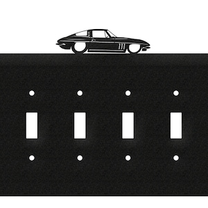 May include: Black metal light switch plate with four toggle switches and a silhouette of a classic car on top.