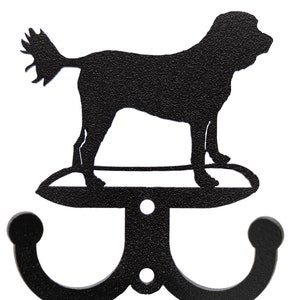 May include: Black metal double hook with a silhouette of a dog standing on a platform. The dog has a long tail and is facing to the right.