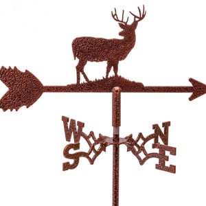 May include: A copper-colored metal deer weathervane with a compass rose and an arrow pointing west. The deer is facing right and has a detailed design.