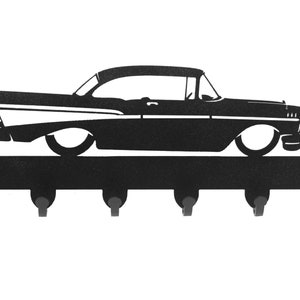 May include: Black metal key holder shaped like a 1957 Chevrolet car with five hooks.