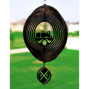 May include: Black metal wind spinner featuring a silhouette of a train and the words "RR" at the bottom. The wind spinner is suspended from a hook against a green backdrop.
