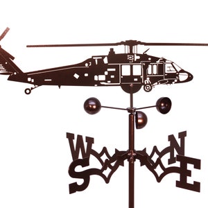 May include: A black metal wind vane featuring a silhouette of a helicopter with a compass rose and the letters N, E, S, and W.