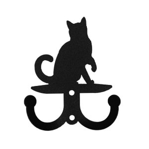 May include: Black metal double hook with a silhouette of a cat sitting on top.