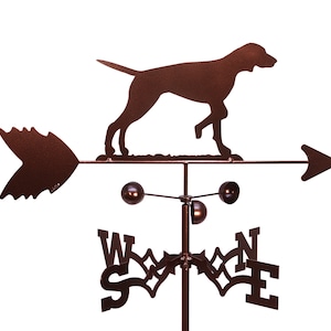 May include: A brown metal weather vane featuring a silhouette of a dog running to the right. The vane has a directional arrow and a compass rose with the letters N, S, E, and W.