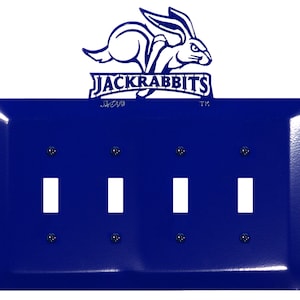May include: A blue metal light switch plate with three toggle switches. The plate features a white silhouette of a jackrabbit with the text "Jackrabbits" above the switches.