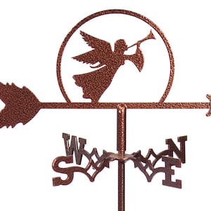 May include: A copper-colored metal weathervane featuring an angel playing a trumpet within a circular frame. The arrow points right, and the directional letters are visible below. The weathervane is designed for outdoor use.
