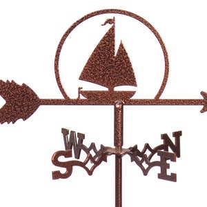 May include: A copper-colored sailboat weather vane with a compass rose and arrow. The sailboat is silhouetted against a sun.