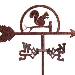 May include: A copper-colored metal squirrel wind vane with a compass rose and arrow. The squirrel is perched on a branch and the wind vane is mounted on a metal pole.