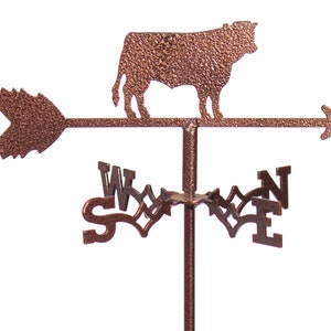 May include: A copper-colored metal cow weathervane with an arrow pointing to the west. The weathervane has a compass rose with the letters N, E, S, and W.