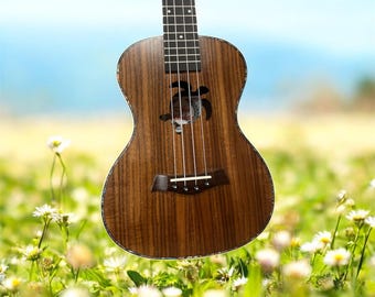 May include: A brown ukulele with a turtle-shaped sound hole. The instrument has four strings and a dark fretboard. The ukulele is set against a blurred background of a field of flowers and a blue sky.
