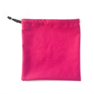 May include: A magenta drawstring pouch made of soft fabric. The pouch has a simple, rectangular shape with a drawstring closure at the top. The drawstring is black. The background is white.