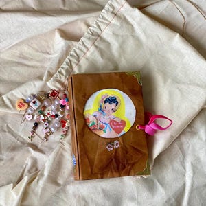 Handgemaakt junkjournaal – omslag in lederlook, venster meisje verzamelt harten, stickers met bloemen, koperen hoeken, vintage ephemera, romantisch cadeau