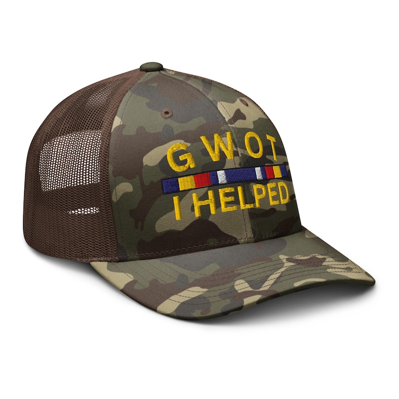 May include: Camouflage baseball cap with a brown mesh back. The front of the cap features the embroidered text "GWOT I HELPED" above a colorful ribbon design. The cap has a curved brim and a button on top.