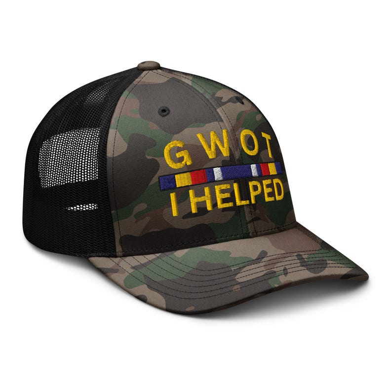 May include: Camouflage baseball cap with a black mesh back. The cap features the embroidered text "GWOT I HELPED" in yellow, with a colorful ribbon design above the text. The cap is a classic trucker style.