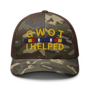 May include: Camouflage trucker hat with the text "GWOT I HELPED" embroidered in yellow. The hat features a brown mesh back and a camouflage front with a colorful ribbon design.
