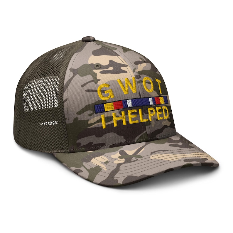 May include: Camouflage trucker hat with a mesh back and curved brim. The hat features the embroidered text "GWOT I HELPED" in yellow, with a colorful ribbon design above the text. The hat is a military-style accessory.