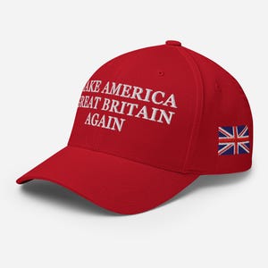 May include: A red baseball cap with white embroidered text reading "MAKE AMERICA GREAT BRITAIN AGAIN". The cap has a small embroidered Union Jack flag on the side.