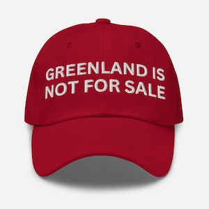 May include: Red baseball cap with white embroidered text that reads "GREENLAND IS NOT FOR SALE".