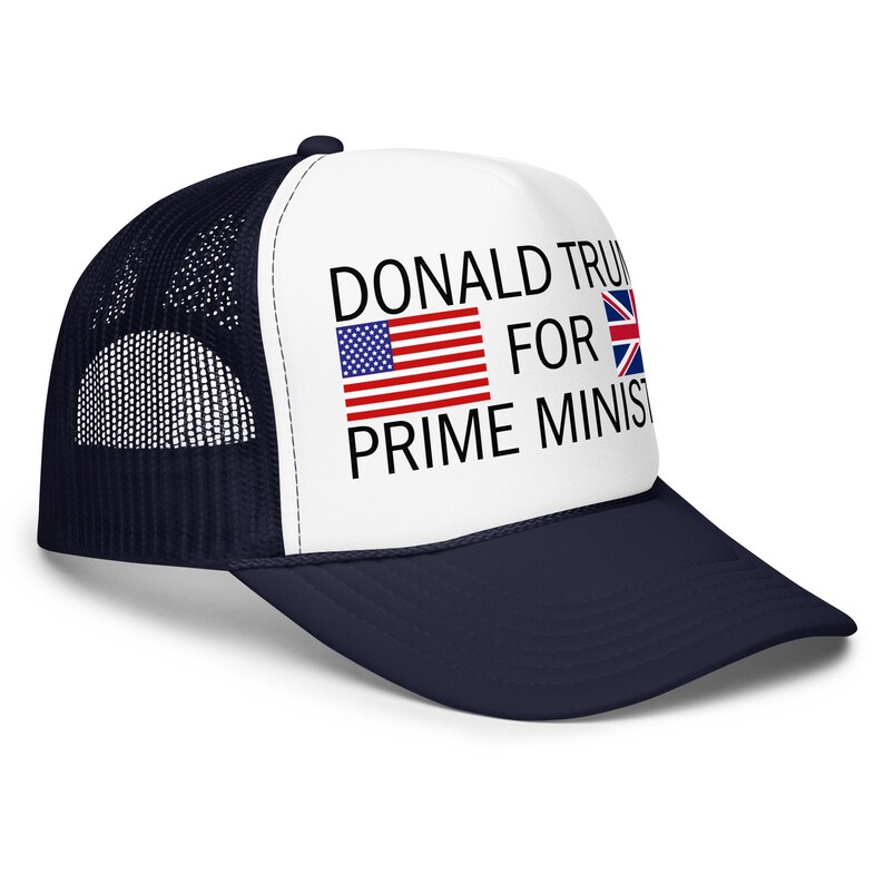 May include: A navy blue and white trucker hat featuring a white front panel with the black text DONALD TRUMP FOR PRIME MINISTER, accompanied by a small United States flag icon and a small United Kingdom flag icon printed on the front panel.
