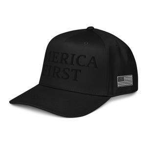 May include: Black baseball cap with the text "AMERICA FIRST" embroidered on the front. The cap also features a small American flag on the side. The hat has a curved brim and a structured fit.