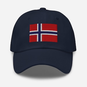 以下が含まれることがあります： 刺繍されたノルウェーの国旗が特徴の、ネイビーブルーの野球帽。国旗のデザインは、白い縁取りのある青い十字が描かれた赤い背景です。帽子はカーブしたつばと構造化されたクラウンを備えています。